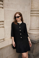 a lady wears a black tweed a-line mini dress